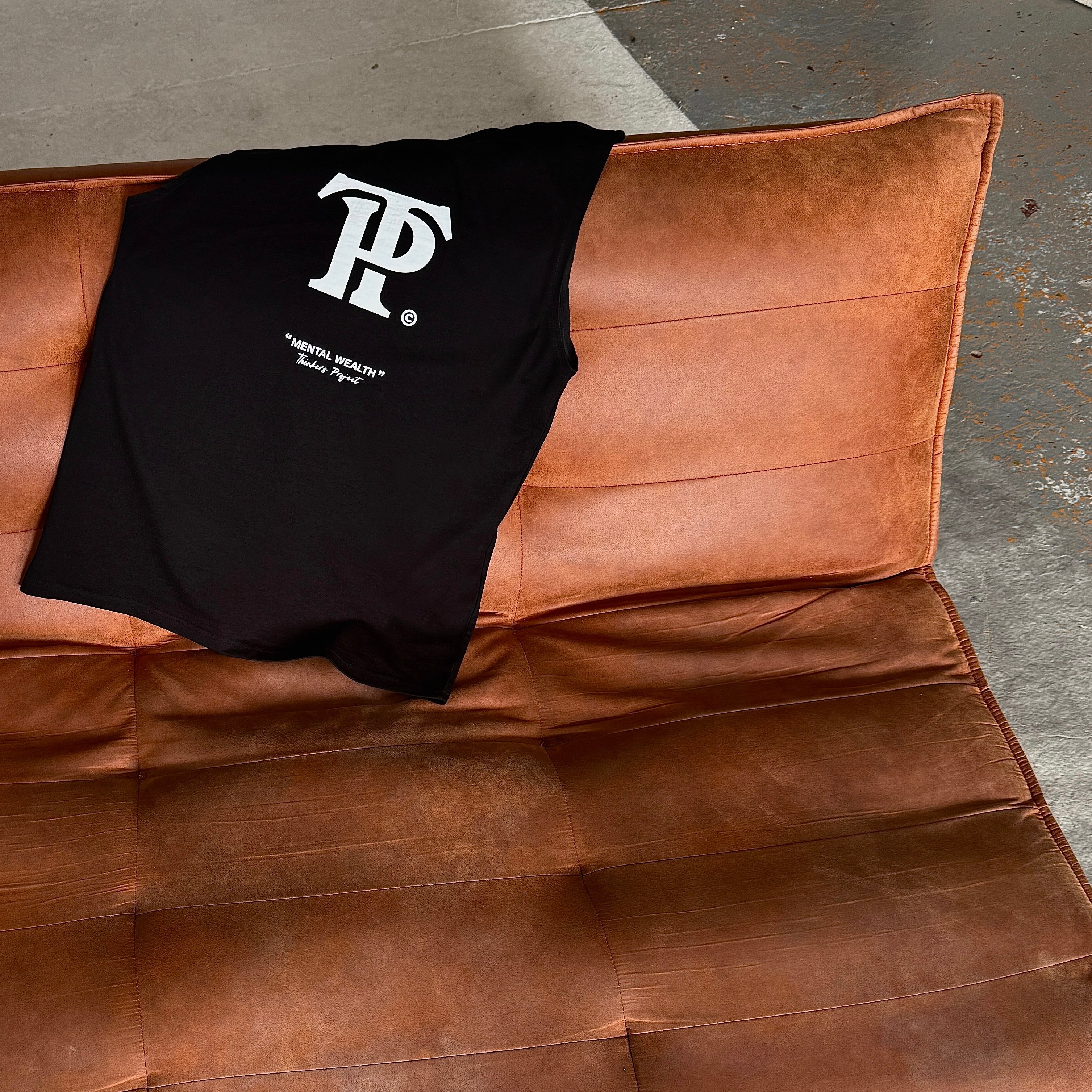 Black t-shirt with a logo on a brown leather surface